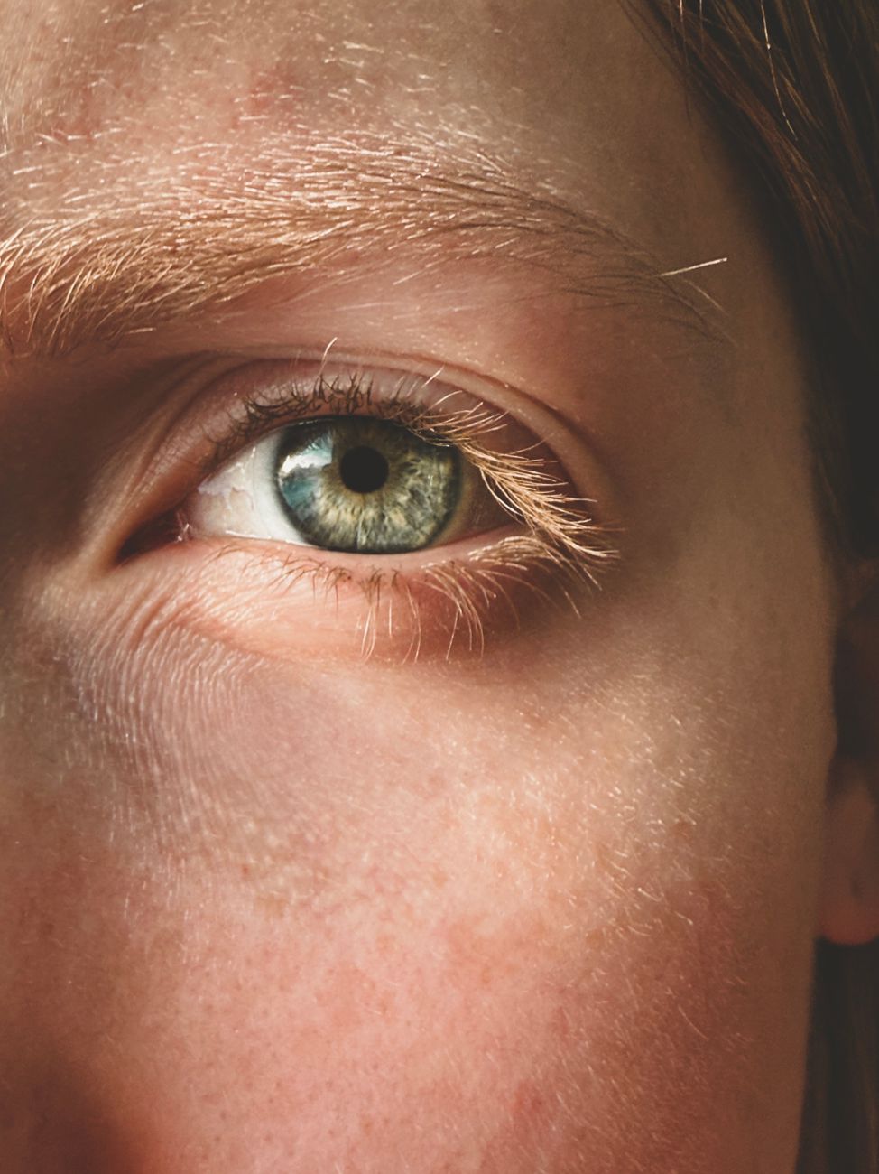 Close-up of a green eye and the fine lines on the skin around it